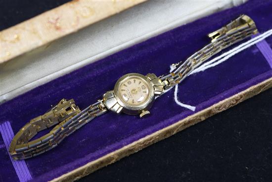 A ladys 14ct gold wrist watch, on a gilt metal bracelet.